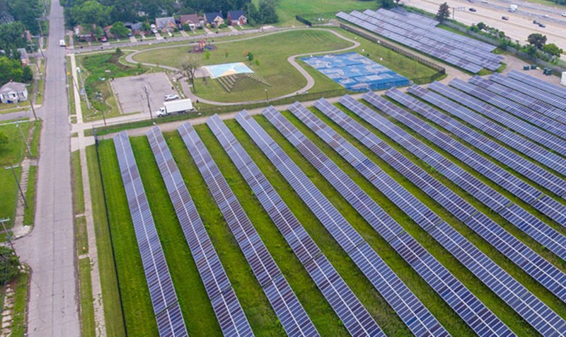 A large solar array in Detroit surrounded by homes, a city park, and a freeway.